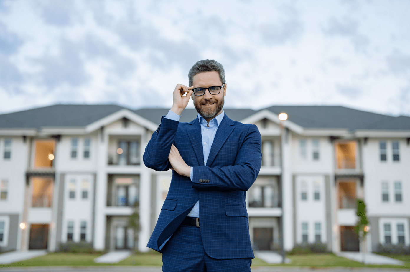real estate agent standing in front of a mansion